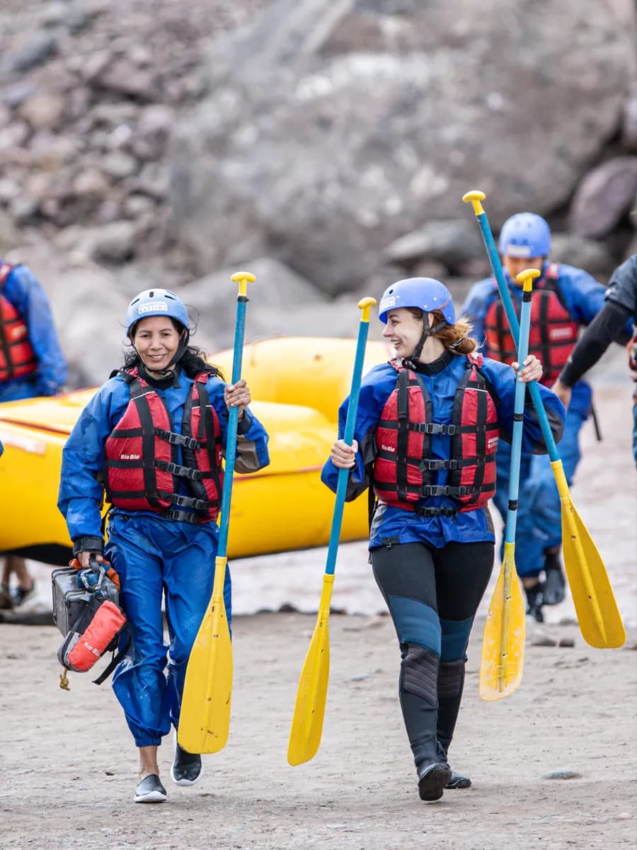 Rafters walking with paddles toward the river