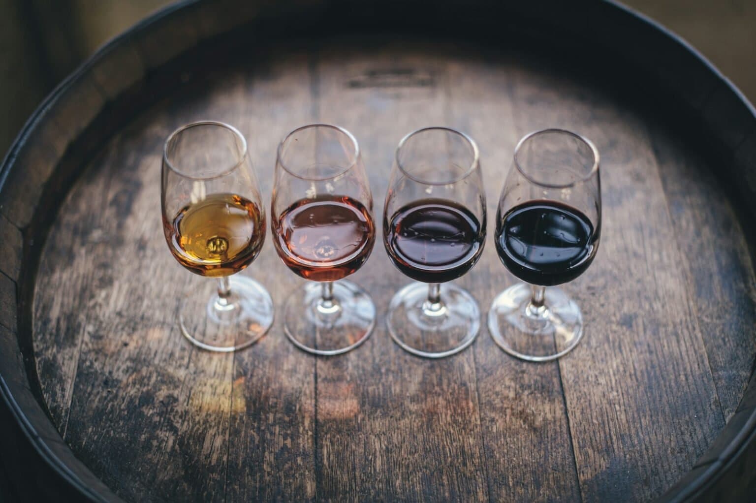 Glasses of red and white wine served on a barrel