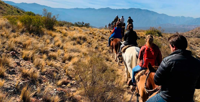 Fila de jinetes cruzando el campo